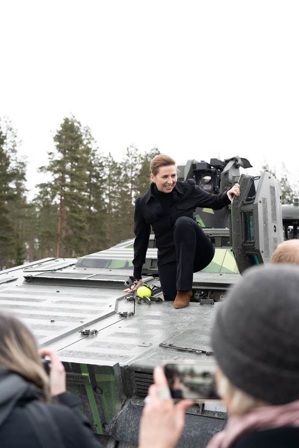 Statsminister Mette Frederiksen på vej ud af en kampvogn