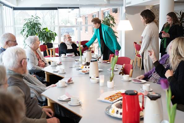 Statsminister Mette Frederiksen hilser på borger på plejecenter Tjørnehaven
