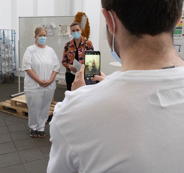 Statsminister Mette Frederiksen taler med personalet og stiller op til fotografering i Øksnehallen efter at have modtage første coronavaccinedosis den 4. juni 2021