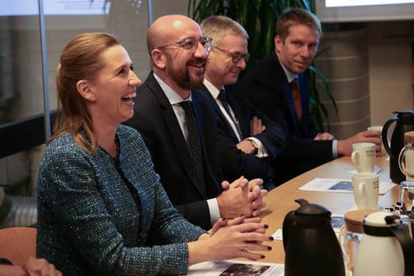 Statsminister Mette Frederiksen og Charles Michel sidder ved et mødebord og drikker kaffe