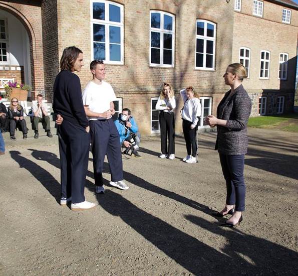 Statsminister Mette Frederiksen hilser på to unge mænd fra Vallekilde Højskole 