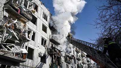 Brandfolk arbejder på at slukke brand efter bombning af by i det østlige Ukraine den 24. februar 2022.