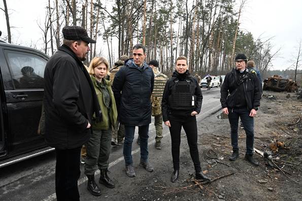 Spaniens premierminister i midten i selskab med statsminister Mette Frederiksen til højre på besøg i byen Borodjanka uden for Kyiv. I grønt til venstre ses Olha Stefanishyna fra den ukrainske regering.
