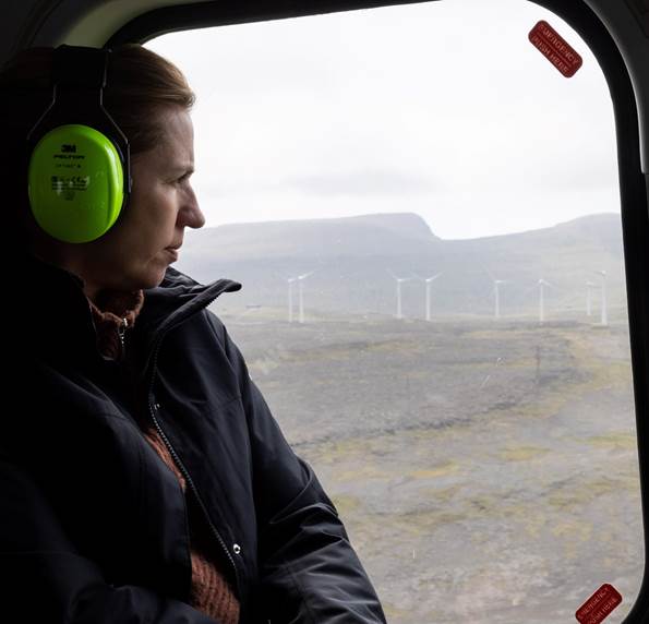 Statsminister Mette Frederiksen passerer vindmøller i helikopter på vej fra den færøeske ø Koltur.