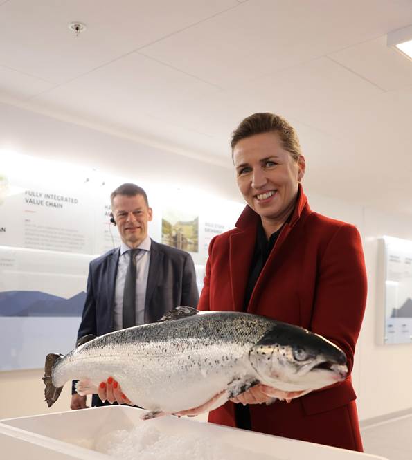 Statsminister Mette Frederiksen på besøg på Færøerne. I sine hænder holder hun en laks. 