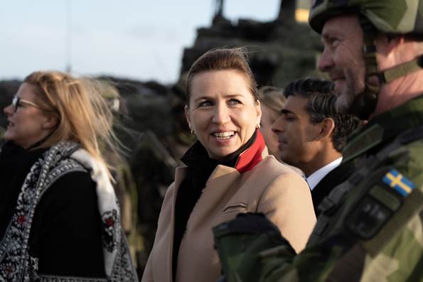 Statsminister Mette Frederiksen smiler ved siden af en svensk soldat til Joint Expeditionary Force 2023