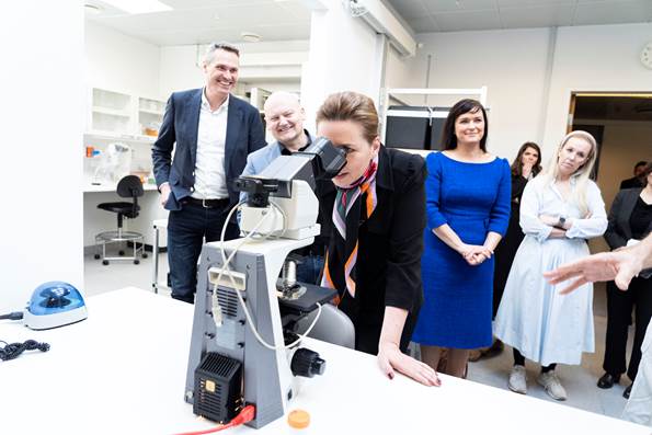 Statsminister Mette Frederiksen kigger gennem et mikroskop