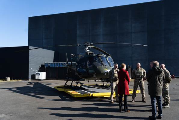 Statsminister Mette Frederiksen foran en helikopter i samtale med personale fra forsvaret