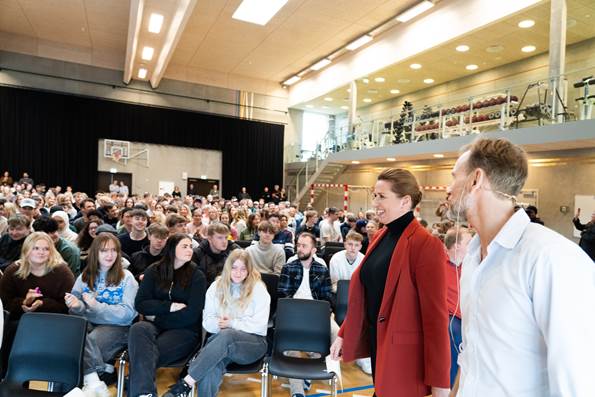 Statsminister Mette Frederiksen med rektoren fra gymnasiet på vej op på scenen